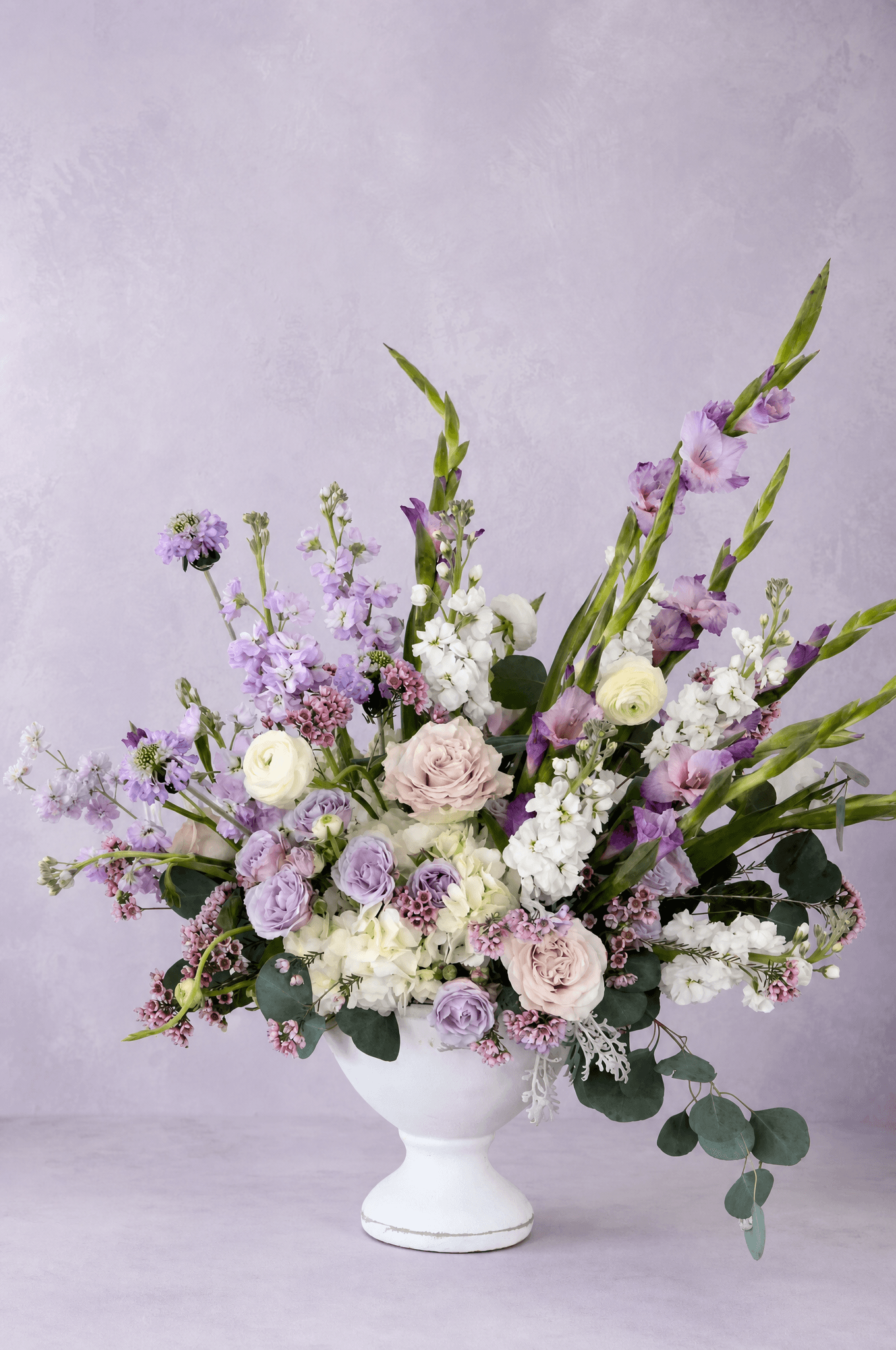 A MoonBloom arrangement — lavender stock, garden roses, gladiolus, and ranunculus
